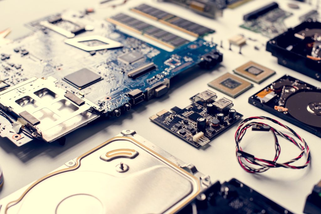 Composants de PC démontés : carte mère, mémoire vive et disques durs